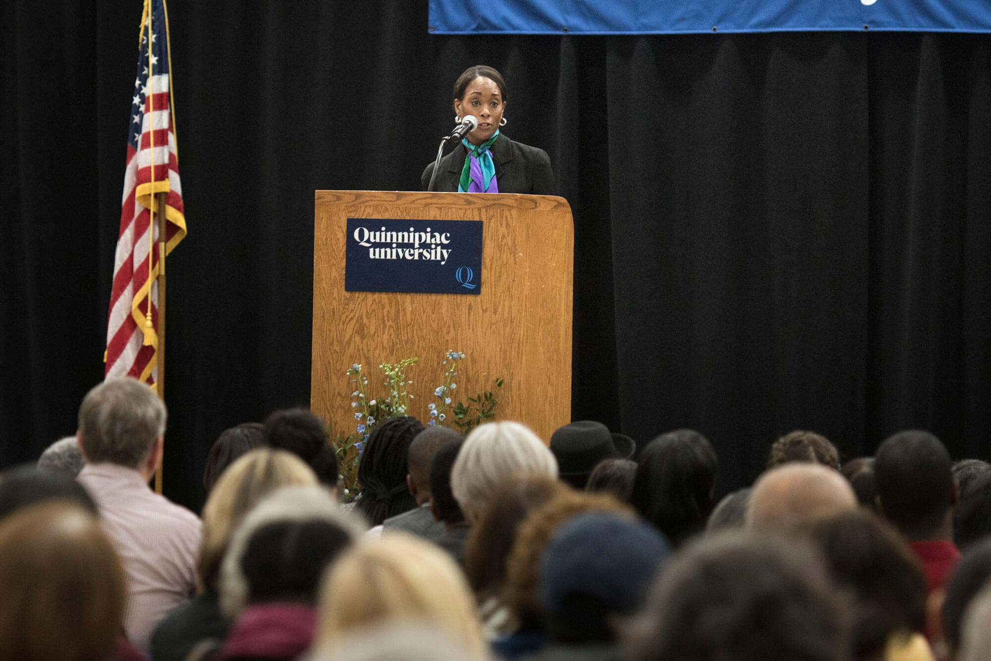 Margot Lee Shetterly speaks at a podium in front of a full audience.
