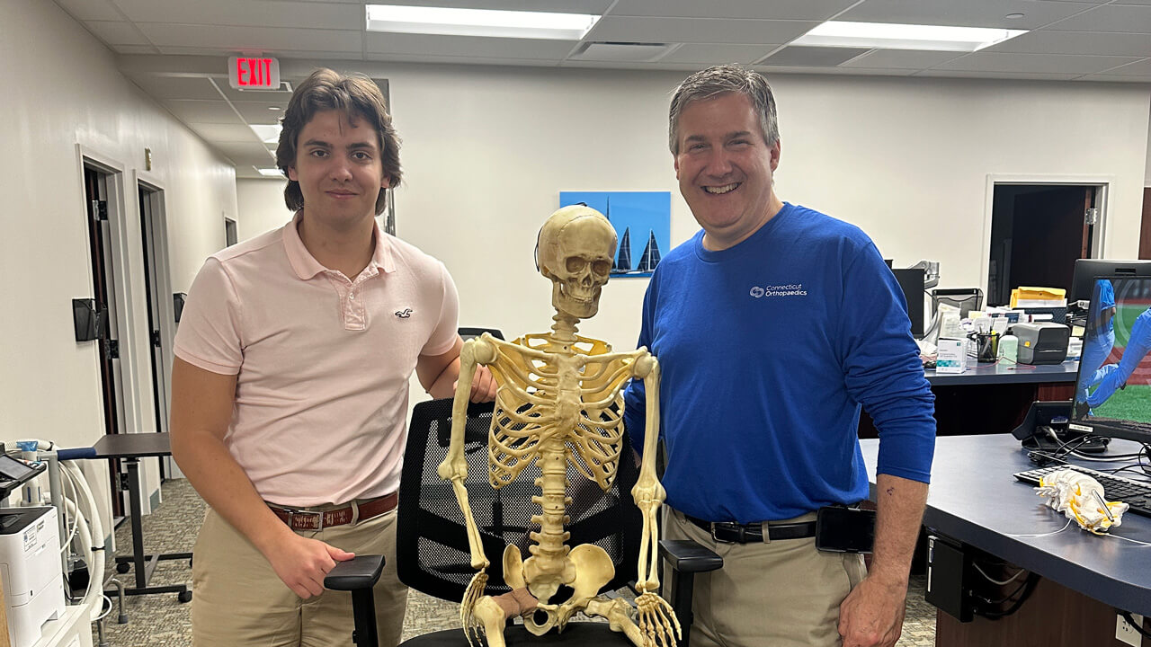 Patrick Zieba with his mentor posing with a skeleton