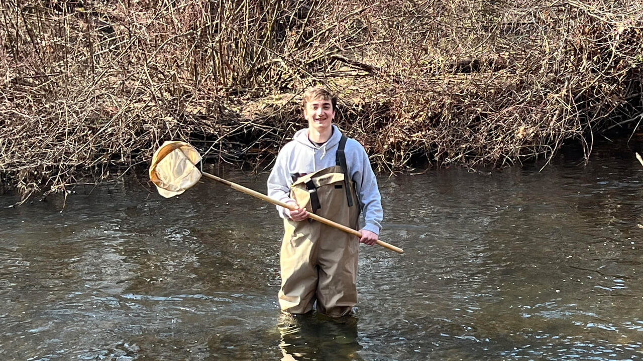 Alex Tamigi in a river with a net