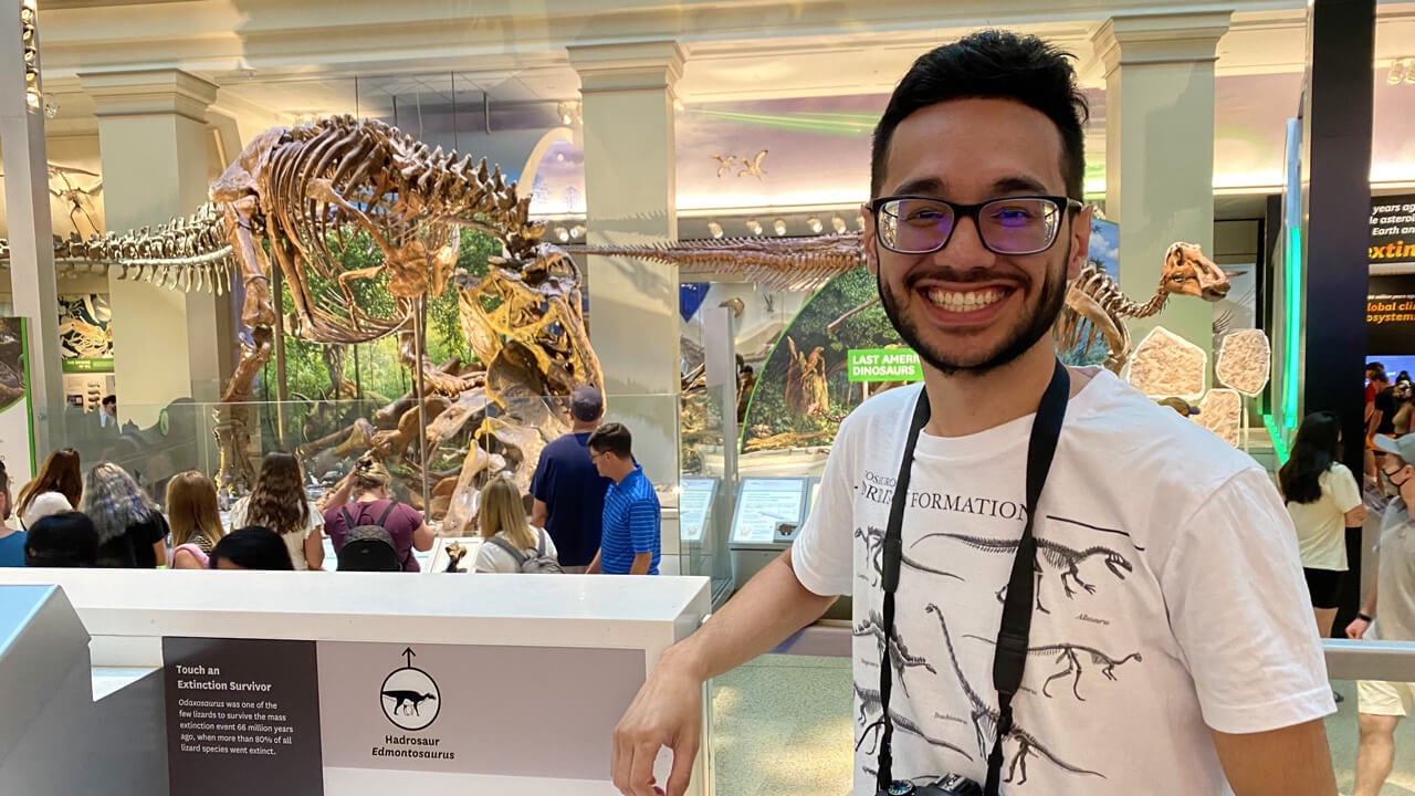 Daniel Galvet in front of a dinosaur skeleton display