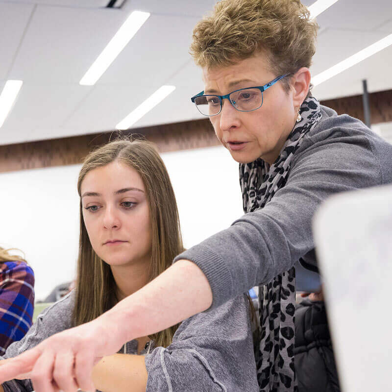 Mary Schramm, Associate Professor of Marketing, works with Sydney Kenyon during class in the Lender School of Business.