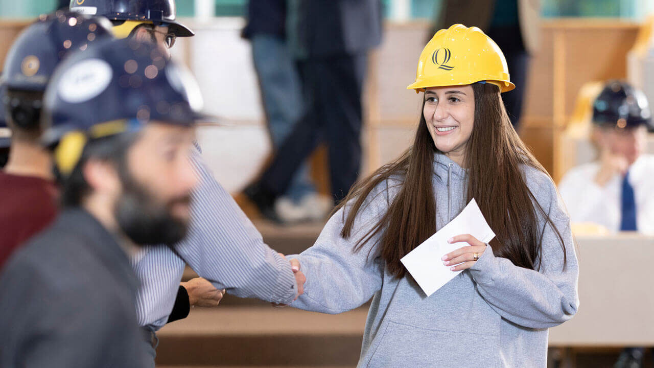 Student smiling while wearing a hard hat.