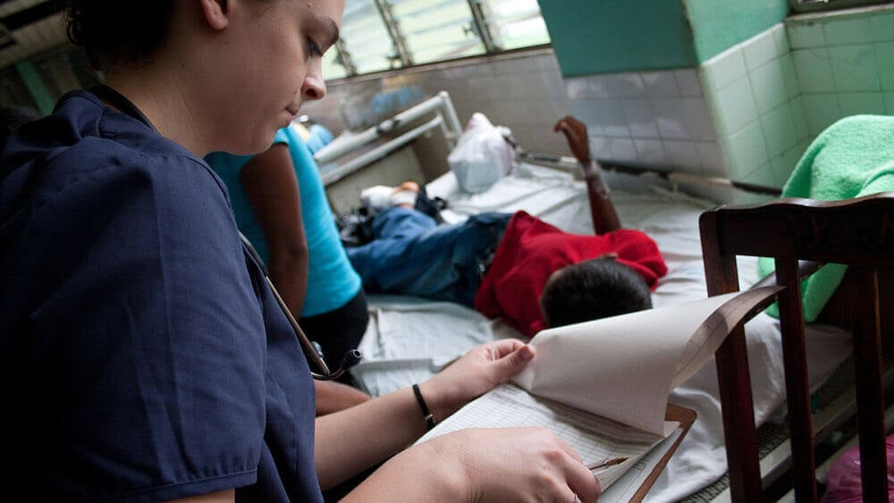 A nursing student checks on a local patient in a Nicaraguan hospital